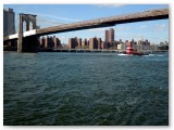 A tugboat chugs under Brooklyn Bridge. 